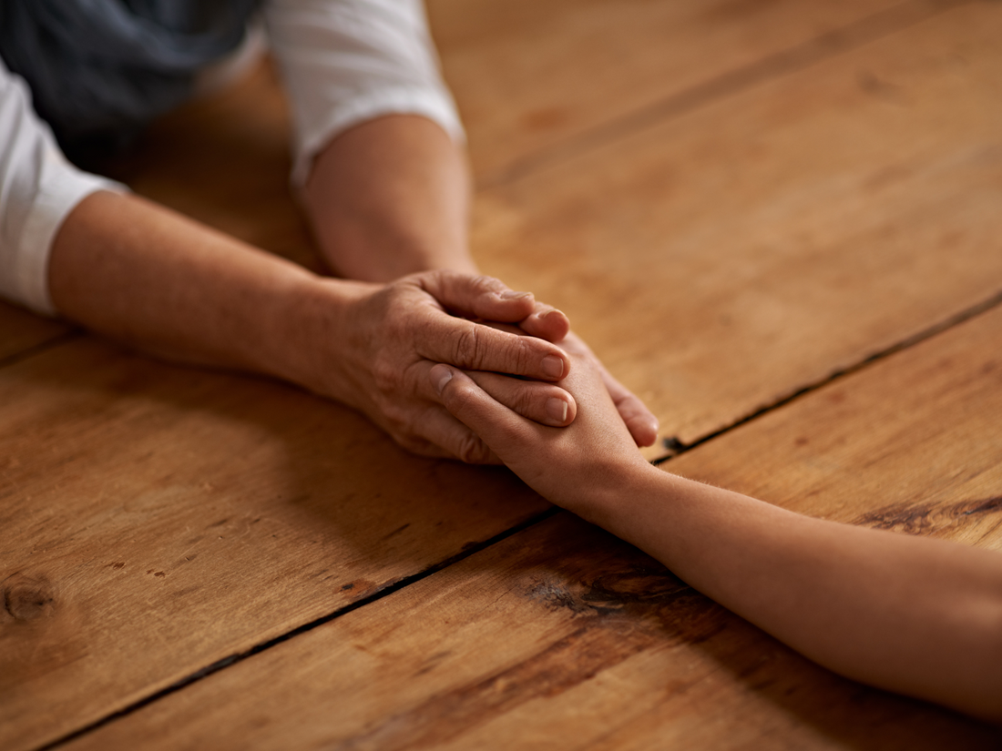 Close-up of hands offering comfort and support after loss, symbolizing compassion after sudden death.